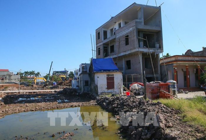 Sau khi nhường đất cho dự án, một số hộ đã bắt đầu xây dựng nhà cửa tại phần đất còn lại. Ảnh: Công Luật - TTXVN 