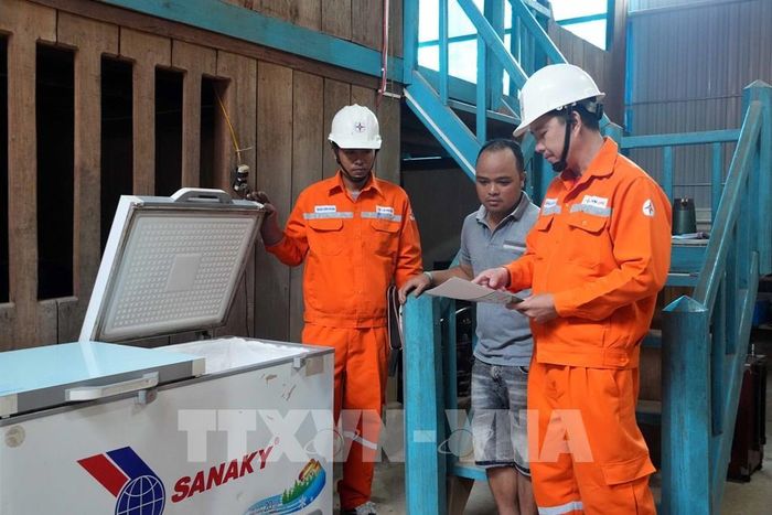 Cán bộ Công ty Điện lực Quảng Trị hướng dẫn người dân bản Cà Ròong, xã Thượng Trạch, sử dụng thiết bị điện an toàn. Ảnh: Tá Chuyên - TTXVN 