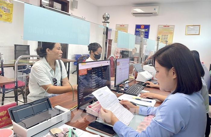 Công chức địa chính - Xây dựng phường Hòa Bình kiểm tra, số hóa quét (scan) hồ sơ gốc lên hệ thống để giải quyết tình trạng thiếu hụt dữ liệu quét của địa phương. Ảnh: Vũ Hà- TTXVN