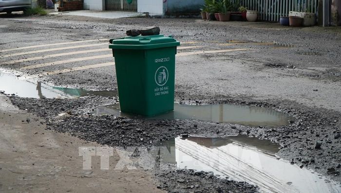 Người dân đặt tạm vật cảnh báo ở những vị trí hư hỏng, nguy hiểm trên đường ĐT-865. Ảnh: Nhựt An - TTXVN
