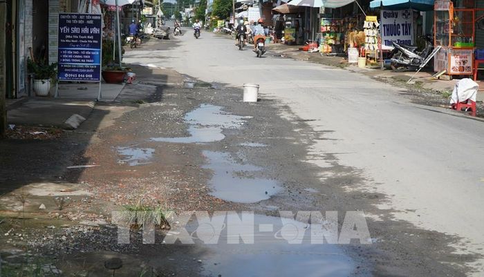 Một phần mặt đường ĐT-865 bị hư hỏng, đọng nước sau mưa gây nguy cơ mất an toàn giao thông. Ảnh: Nhựt An - TTXVN