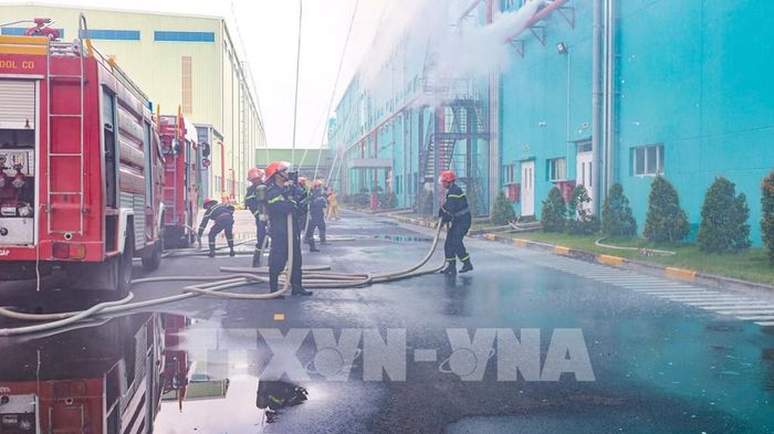Lực lượng Cảnh sát phòng cháy, chữa cháy và cứu nạn, cứu hộ triển khai phương tiện, đội hình xử lý tình huống cháy giả định tại Công ty TNHH Sợi, Dệt Nhuộm Unitex. Ảnh: Minh Phú – TTXVN