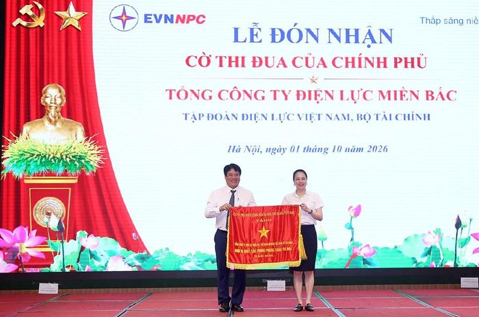 Thừa ủy quyền của Thủ tướng Chính phủ, ông Nguyễn Anh Tuấn - Phó Bí thư Đảng ủy, Thành viên HĐTV, Tổng giám đốc EVN trao Cờ Thi đua của Chính phủ cho bà Đỗ Nguyệt Ánh - Bí thư Đảng ủy, Chủ tịch HĐTV EVN. Ảnh: EVNNPC