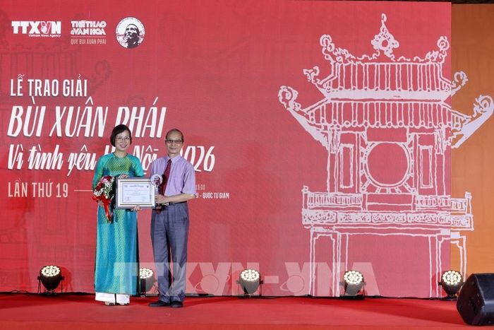 Nhà báo Vũ Việt Trang, Ủy viên Ban Thường vụ Đảng ủy các cơ quan Đảng Trung ương, Phó Trưởng Ban Tuyên giáo Trung ương, Bí thư Đảng ủy, Tổng Giám đốc Thông tấn xã Việt Nam trao giải thưởng cho nhà văn Bằng Việt. Ảnh: Phạm Tuấn Anh - TTXVN