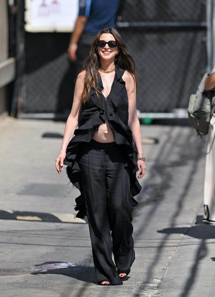 Anne Hathaway xuất hiện trên chương trình Jimmy Kimmel Live! trong bộ trang phục màu đen mang phong cách lãng mạn của Lein, kết hợp cùng trang sức, kính râm và túi xách của Bulgari. Cô hoàn thiện diện mạo với đôi giày cao gót hở mũi màu đen đồng điệu của Aquazzura. Ảnh: Getty Images