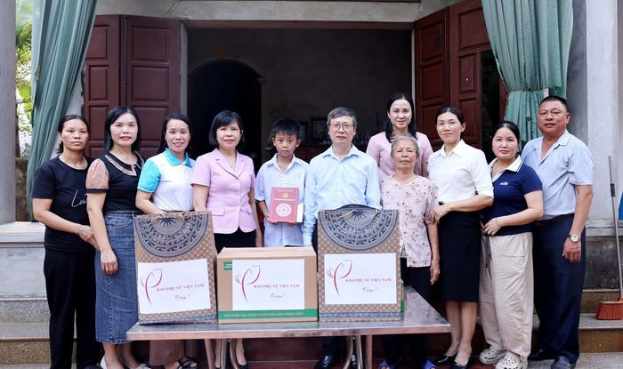 Ông Phí Quốc Thuyên, Bí thư Chi bộ, Tổng Biên tập Báo Phụ nữ Việt Nam, cùng con đỡ đầu Nguyễn Ngọc Tiến và gia đình chụp ảnh lưu niệm với lãnh đạo xã Phúc Thọ.