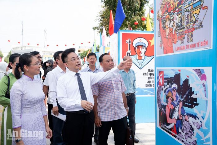 Các đại biểu tham quan, tìm hiểu các tác phẩm tranh cổ động tấm lớn tại triển lãm.