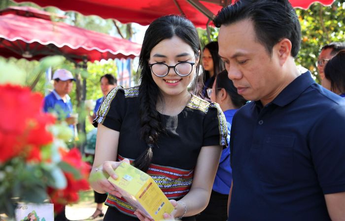 Thiếu nữ Ca Dong giới thiệu sản phẩm đặc trưng từ sâm Ngọc Linh với du khách tham quan. Ảnh: ALĂNG NGƯỚC