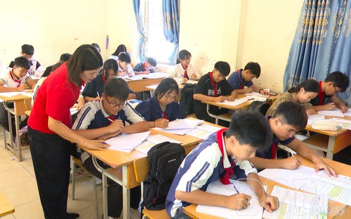 Sau sắp xếp, các cơ sở giáo dục trên địa bàn tỉnh công khai nội dung, khoản thu đế sớm ổn định công tác dạy và học. Trong ảnh: Giáo viên Trường Phổ thông dân tộc bán trú THCS Mường Nhé hướng dẫn học sinh làm bài tập.