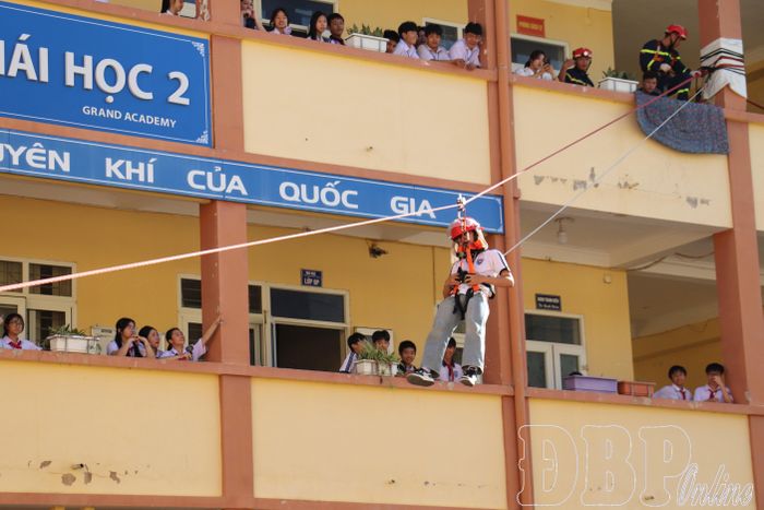 Học sinh thực hành kỹ năng thoát nạn từ trên cao xuống bằng dây.