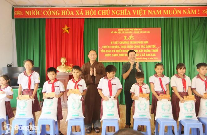 Các em học sinh thuộc gia đình khó khăn ở xã Đak Lua nhận quà do lãnh đạo Sở Dân tộc và Tôn giáo cùng mạnh thường quân trao tặng. Ảnh: Văn Truyên