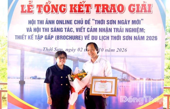 Bà Nguyễn Thị Xuân Mai, Phó Chủ tịch UBND phường Thới Sơn trao giải Nhất cuộc thi ảnh online cho tác giả Cao Lập Đức.