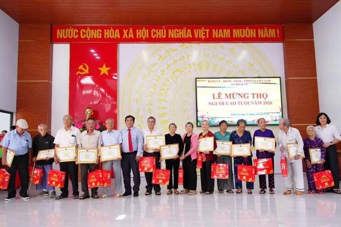 Các cụ cao tuổi ở xã Hoài Ân nhận thiếp mừng thọ và quà tại buổi lễ. Ảnh: T.Q