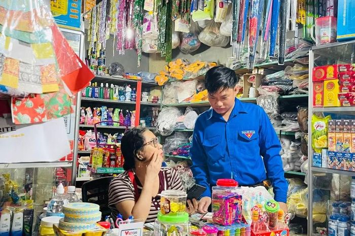  Tổ công nghệ số cộng đồng hướng dẫn tiểu thương chợ Ân Hữu tiếp cận các tiện ích số. Ảnh: Minh Hoàng 
