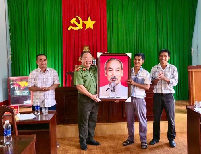  Thiếu tướng Lê Quang Nhân (thứ 2 từ trái sang) tặng ảnh Chủ tịch Hồ Chí Minh cho Chi bộ làng Lung Prông. Ảnh: Thanh Tịnh 