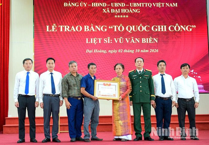 Đại biểu chụp ảnh lưu niệm cùng thân nhân gia đình liệt sĩ Vũ Văn Biền.