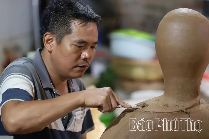 Hoạ sỹ Nguyễn Hồng Quang ở Xưởng gốm Quang Minh say sưa bên tác phẩm gốm.
