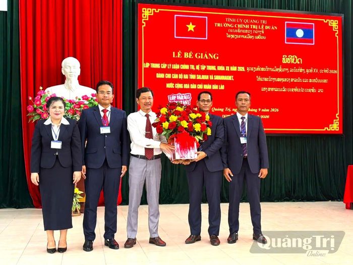 Học viên Lào tặng hoa cho đại diện Ban Giám hiệu Trường Chính trị Lê Duẩn sau khi kết thúc khóa học - Ảnh: H.H