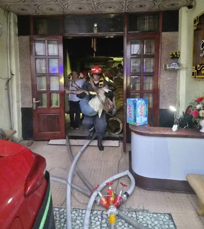 Nạn nhân bị mắc kẹt trong đám cháy được cán bộ chiến sĩ khẩn trương hỗ trợ, giúp thoát ra ngoài an toàn.