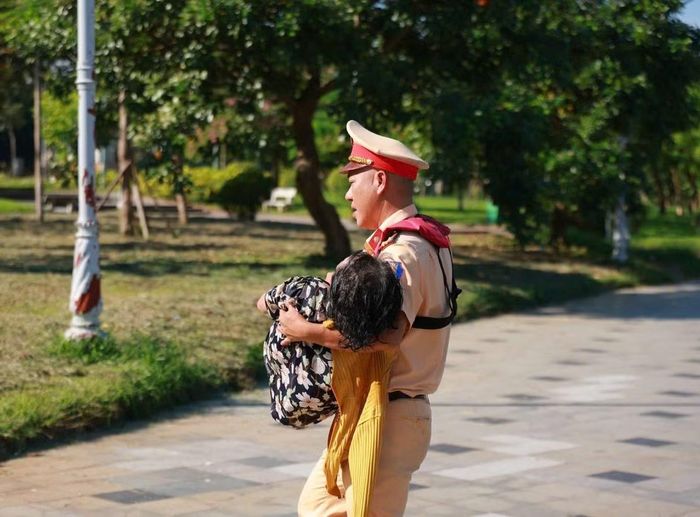 Trung tá Nguyễn Đình Xà hỗ trợ đưa nạn nhân lên xe taxi.