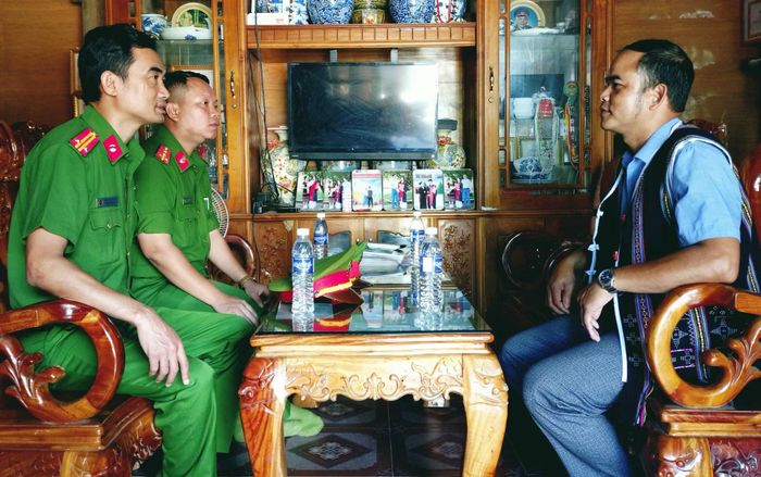 Cán bộ Công an xã Đông Giang trò chuyện với ông Bnướch Ngang về tình hình an ninh, trật tự tại địa phương.