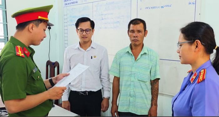 Cơ quan CSĐT Công an tỉnh Khánh Hòa tống đạt quyết định khởi tố bị can và công bố lệnh bắt tạm giam Huỳnh Văn Đông (thứ hai, từ phải sang). Ảnh: Tiến Quân.