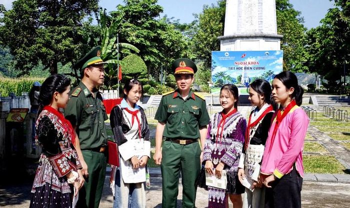 Cán bộ Đồn Biên phòng A Mú Sung, Bộ chỉ huy Quân sự địa phương trò chuyện cùng các em học sinh về biên giới, cột mốc quốc gia. Ảnh: Minh Quân