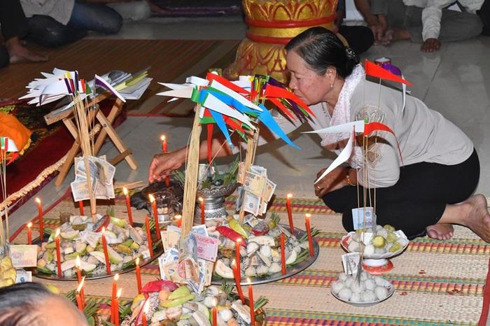 Bà Thị Rel (ấp Đường Đào, xã Hồ Thị Kỷ), các thế hệ trong gia đình cũng đang cùng nhau chuẩn bị lễ vật để mang lên chùa. Bà Nhung tỉ mỉ xếp từng vắt cơm, chuẩn bị đĩa hoa quả và tiền lẻ đặt lên mâm tròn.