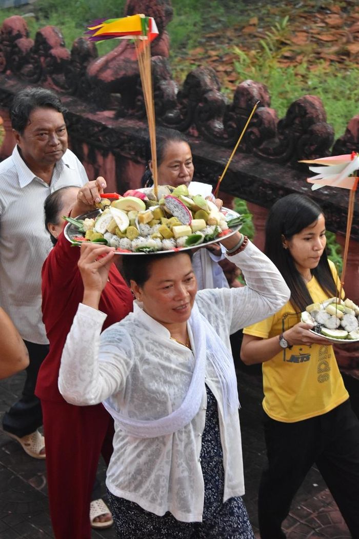 Bà Hữu Thị Nhung (ấp Đường Đào, xã Hồ Thị Kỷ) đang đội mâm tròn cơm vắt vòng quanh Chính điệntỏ lòng thành kính Tam Bảo và Tổ tiên.