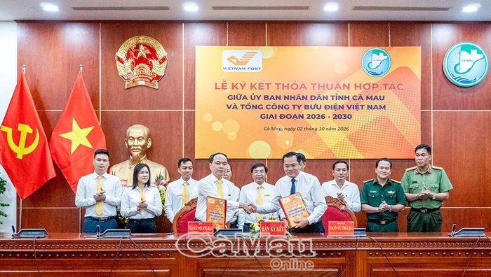 Phó Chủ tịch UBND tỉnh Ngô Vũ Thăng (hàng đầu, bìa phải) cùng Phó Tổng Giám đốc Tổng Công ty Bưu điện Việt Nam Nguyễn Quang Hải ký kết thoả thuận hợp tác.