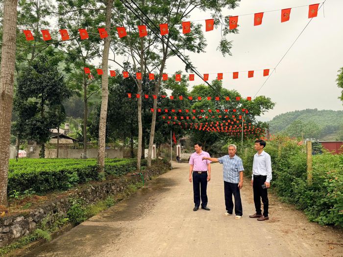  Ông Trương Văn Dũng (thứ hai từ phải sang) tích cực vận động người dân hiến đất, mở rộng tuyến đường giao thông nông thôn rộng 6m. (Ảnh: Thảo Khánh).