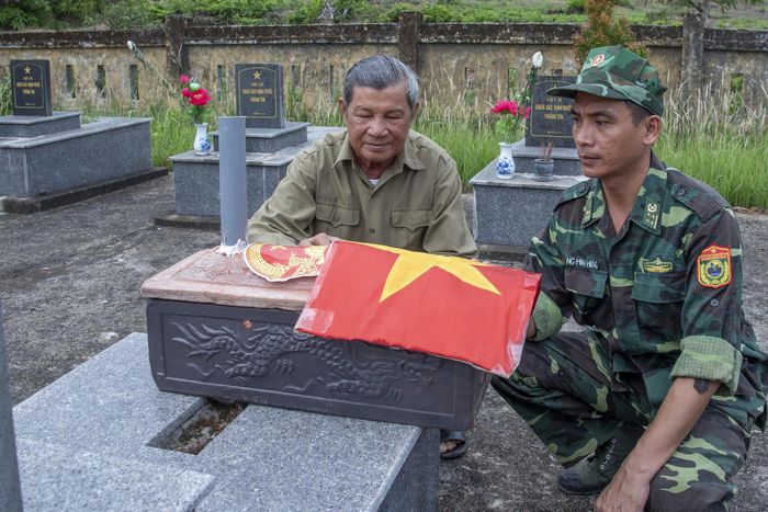 Cựu chiến binh Nguyễn Văn Kiệt bên hài cốt của đồng đội