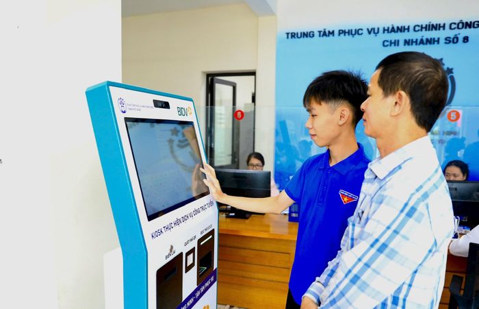 Đoàn viên thanh niên hỗ trợ người dân thực hiện dịch vụ công trực tuyến tại Trung tâm Phục vụ hành chính công thành phố Hà Nội - chi nhánh số 8. Ảnh Phạm Hùng