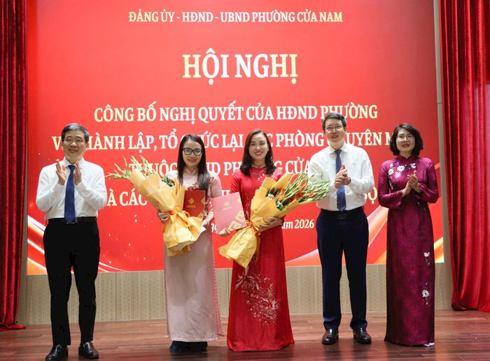 Các đồng chí Thường trực Đảng ủy phường trao quyết định và tặng hoa chúc mừng lãnh đạo Phòng Văn hoá - Xã hội. Ảnh: PV
