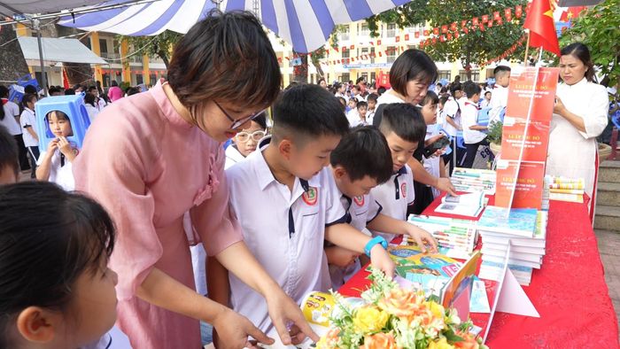 Giáo viên và các em học sinh tham quan không gian trưng bày sách với nhiều đầu sách phong phú về lịch sử, văn hóa, giáo dục, kỹ năng sống, chuyển đổi số và học tập suốt đời. Ảnh: Nguyễn Lý