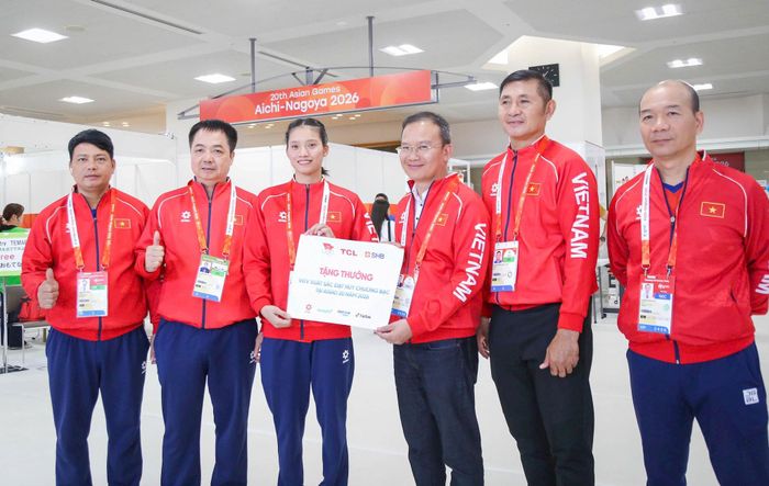 Võ sĩ Nguyễn Thị Tâm nhận thưởng nóng từ lãnh đạo Đoàn Thể thao Việt Nam ở ASIAD 20. Trong thành công của cô có dấu ấn của HLV Nguyễn Như Cường (thứ hai từ trái sang) và chuyên gia Tawan Mungphingklang (thứ hai từ phải sang). Ảnh: Long Nguyễn.