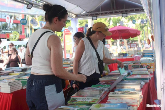 Du khách nước ngoài thích thú tham quan các không gian trưng bày, tìm hiểu sách và chọn mua những cuốn sách thể hiện những giá trị văn hóa, lịch sử của Thăng Long - Hà Nội.