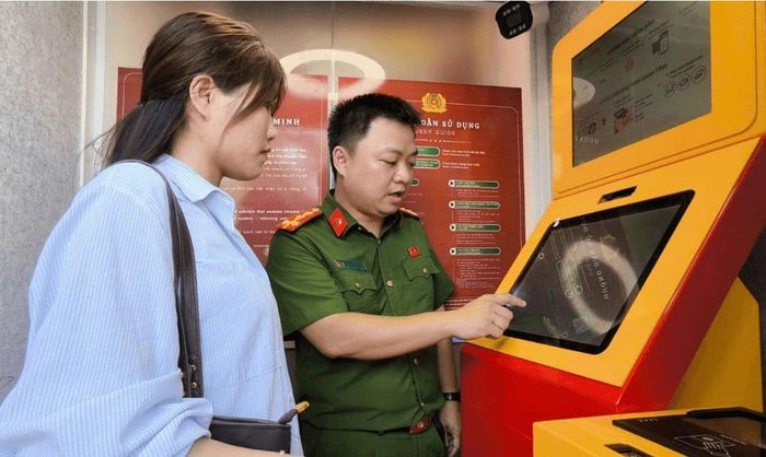 Người dân được cán bộ Công an hướng dẫn trải nghiệm ứng dụng Hanoi Smart Police. Ảnh: Công an thành phố Hà Nội