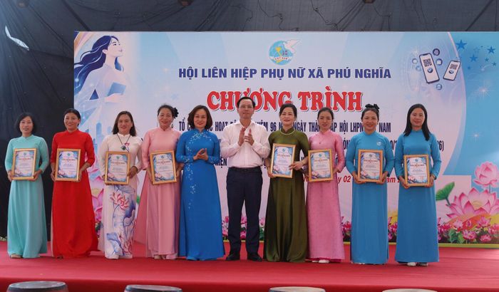 Phó Chủ tịch Thường trực Hội Liên hiệp phụ nữ Hà Nội Phạm Thị Thanh Hương và Bí thư Đảng ủy, Chủ tịch HĐND xã Phú Nghĩa Trịnh Tiến Tường trao giấy chứng nhận đại diện các tổ chức, cá nhân tham gia phiên chợ không dùng tiền mặt. Ảnh: Kim Nhuệ