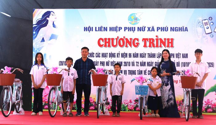 Chủ tịch Hội Liên hiệp phụ nữ xã Phú Nghĩa Đào Thị Hòa và đơn vị tham gia chương trình tặng quà cho trẻ em trên địa bàn. Ảnh: Kim Nhuệ