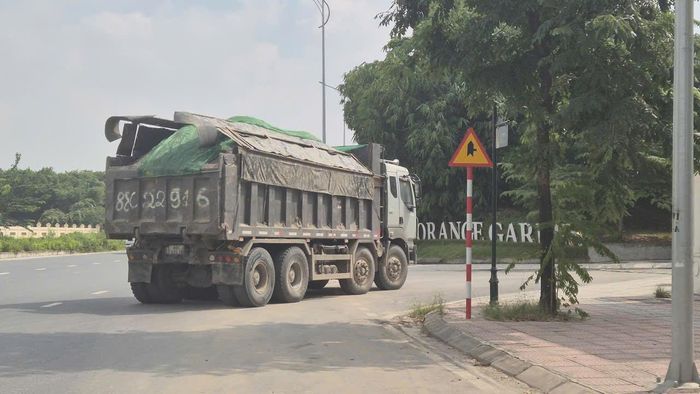 Xe chở đất vào dự án Khu biệt thự Vườn Cam (tên thương mại là Orange Garden), xã Sơn Đồng, cao vượt quá thành thùng, có dấu hiệu chở quá tải. Ảnh: HL