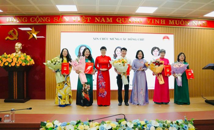 Lãnh đạo phường Kim Liên trao quyết định, tặng hoa chúc mừng lãnh đạo 5 phòng chuyên môn. Ảnh: PV