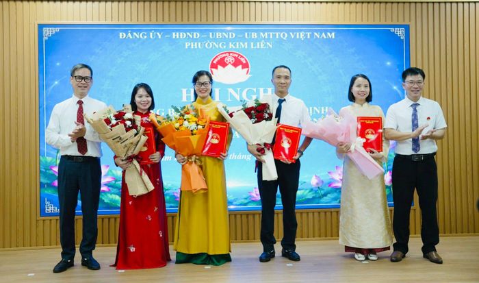 Lãnh đạo phường Kim Liên trao quyết định, tặng hoa chúc mừng cán bộ được bổ nhiệm thuộc 5 phòng chuyên môn vừa kiện toàn. Ảnh: PV