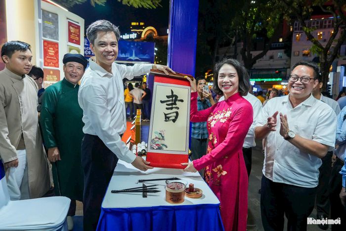 Phó Chủ tịch UBND thành phố Hà Nội Vũ Thu Hà tham gia hoạt động trải nghiệm văn hóa như viết thư pháp tại Hội Sách. Ảnh: Duy Khánh