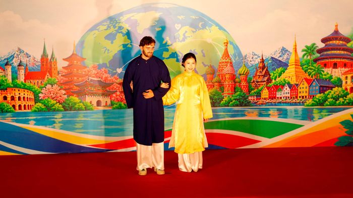 Sinh viên Nathan (Pháp) cùng nữ sinh Trung Quốc trình diễn trang phục áo dài Việt Nam. Ảnh: Hồng Giang