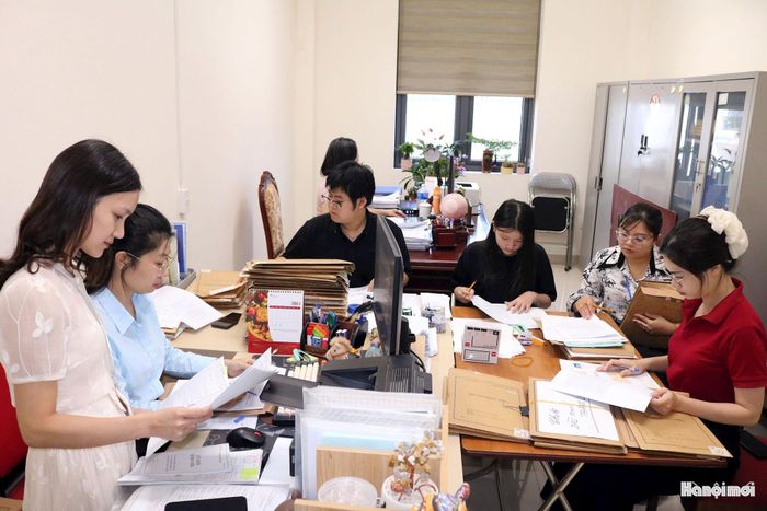 Cán bộ phường Xuân Đỉnh phân loại hồ sơ, xử lý cuốn chiếu từng nhóm. Ảnh: MT