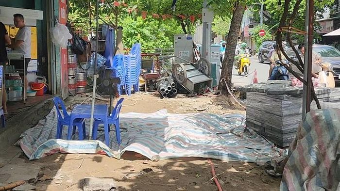 Một quán bia trải bạt trên nền vỉa hè để chắn bụi và mở lối đi tạm cho khách. Ảnh: VA.