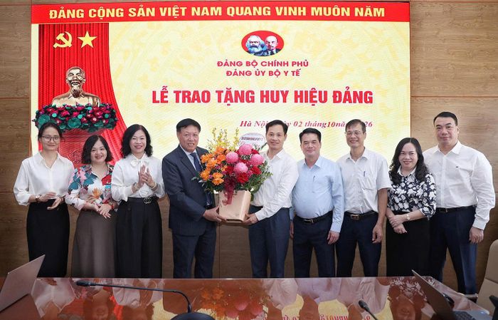 Đồng chí Phạm Minh Khuê, Phó Bí thư Chuyên trách Đảng ủy Bộ Y tế và các đồng chí thuộc các Ban Đảng, Uỷ ban kiểm tra, Văn phòng Đảng uỷ Bộ Y tế chúc mừng đồng chí Đỗ Xuân Tuyên. Ảnh: Trần Minh