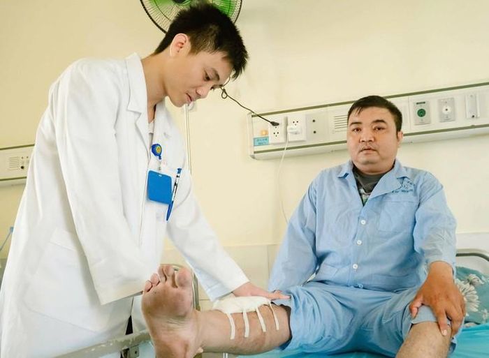 Anh Nguyễn Văn Minh được nhân viên y tế kiểm tra vết thương ở chân. Ảnh: BVCC.