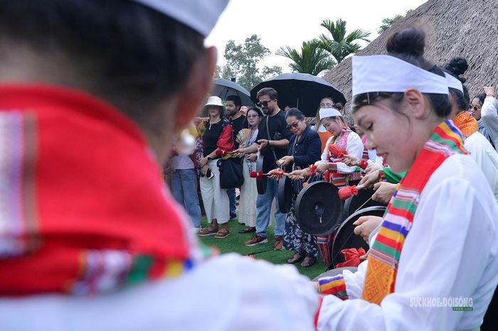 Du khách quốc tế trực tiếp trải nghiệm đánh chiêng dưới sự hướng dẫn của người Mường. Ảnh: Tuấn Anh